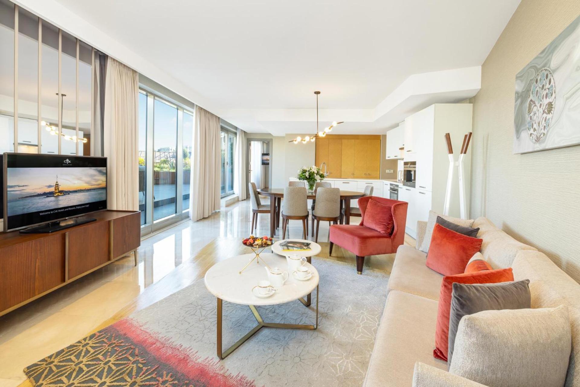 Cvk Park Bosphorus Hotel Istanbul Exterior photo The photo shows a modern and elegantly designed living space. It features a bright, open layout with large windows that let in natural light. The area includes a comfortable seating arrangement with a light-colored sofa and two stylish armchairs in r
